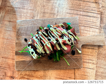 Delicious steak sandwich on a wooden cutting board Delicious steak sandwich on a wooden cutting board 126731715