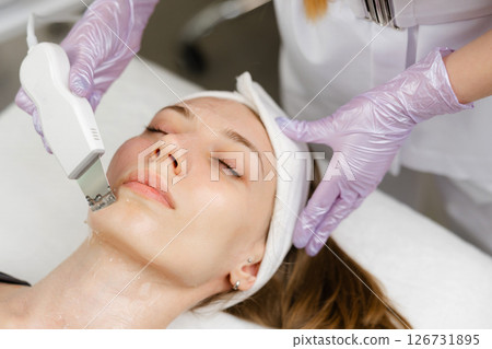 Beautician performing ultrasonic facial cleansing on woman Beautician performing ultrasonic facial cleansing on woman 126731895