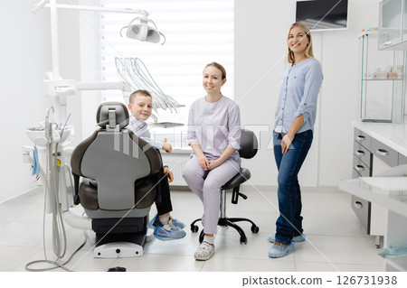 Dentist explaining dental hygiene to mother and child in clinic 126731938