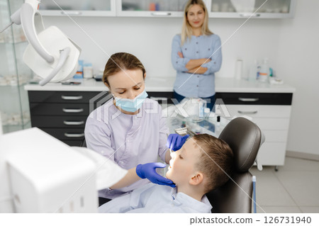 Female dentist examining teeth of child patient in dental clinic 126731940