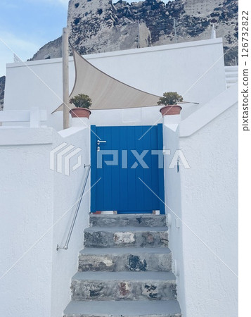 A blue gate in front of a house on the island of Santorini in Cycladic style A blue gate in front of a house on the island of Santorini in Cycladic style 126732822