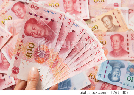 Big pile of different Chinese yuan banknotes 100 in hand. Chinese paper currency Yuan renminbi banknotes and coins. Copy space. Close up. 126733051