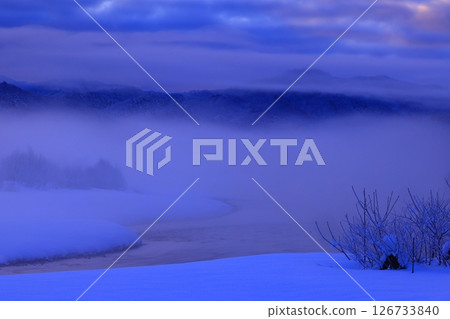 Rime-colored trees and river mist in the morning sun 126733840