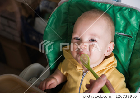 Happy Baby Being Fed by Grandmother at Home 126733910