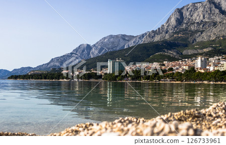 Makarska beach with Biokovo mountains in the bckground. Crystalline waters and charming views Makarska beach with Biokovo mountains in the bckground. Crystalline waters and charming views 126733961