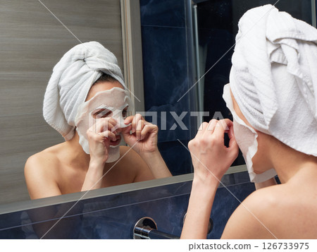 Woman put face mask at bathroom 126733975