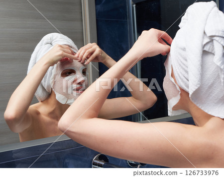 Woman put face mask at bathroom Woman put face mask at bathroom 126733976