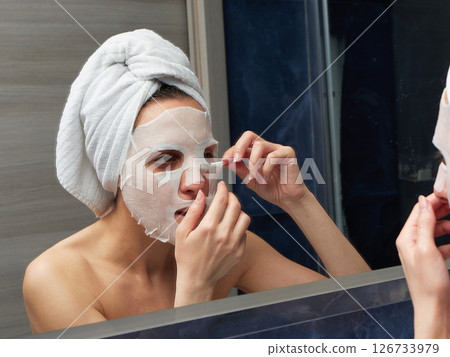 Woman put face mask at bathroom 126733979