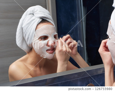Woman put face mask at bathroom 126733980