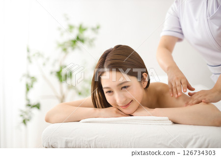 A woman in her twenties receiving a massage at a beauty salon A woman in her twenties receiving a massage at a beauty salon 126734303