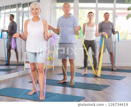 Elderly woman exercises with pilates band Elderly woman exercises with pilates band 126734419