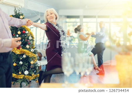 Middle-aged man and elderly woman dancing contemporary discofox in couple in New Year atmosphere 126734454