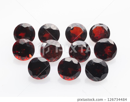 A stunning collection of round-cut, deep red natural garnets presented against a clean white background, showcasing their brilliance and clarity gemstones are arranged in an artful composition A stunning collection of round-cut, deep red natural garnets presented against a clean white background, showcasing their brilliance and clarity gemstones are arranged in an artful composition 126734484