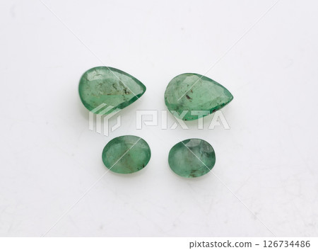 Natural Emerald Gemstones Collection Featuring Two Pear-Cut and Two Round-Cut Untreated Loose Emeralds Displayed on a White Surface, Vivid Green Color, Jewelry Making 126734486