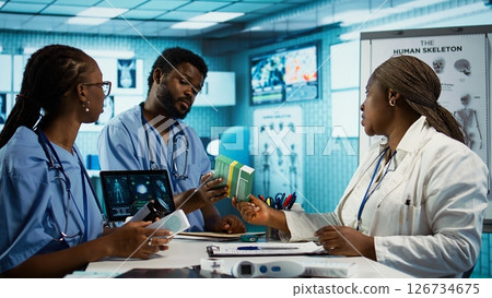 Male and female nurses in scrubs engaged in professional training and research with expert physician, care management. Medic offers them stock of medicine and drugs for remedy. Camera B. Male and female nurses in scrubs engaged in professional training and research with expert physician, care management. Medic offers them stock of medicine and drugs for remedy. Camera B. 126734675