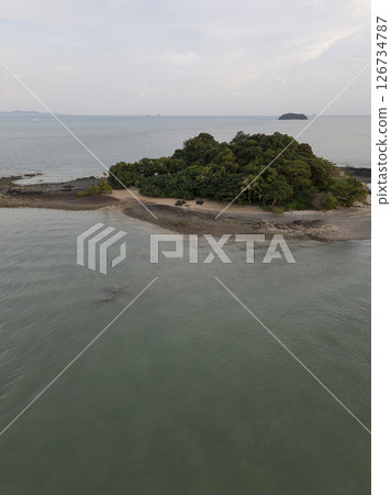 Aerial view of a majestic small Thai island with sailboats around the shore, amazing travel destination featuring crystal clear waters and dense rainforests. Tropical landscape. Aerial view of a majestic small Thai island with sailboats around the shore, amazing travel destination featuring crystal clear waters and dense rainforests. Tropical landscape. 126734787