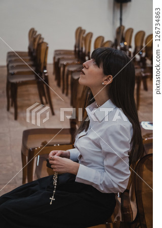 Woman Immersed In The Prayer At The Church With A Rosary  126734863