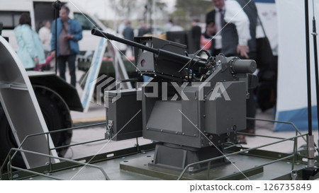Military Technology Display Features a Modern Turreted Weapon System at an Outdoor Exhibition in the Afternoon, Showcasing Advancements in Defense Equipment Military Technology Display Features a Modern Turreted Weapon System at an Outdoor Exhibition in the Afternoon, Showcasing Advancements in Defense Equipment 126735849
