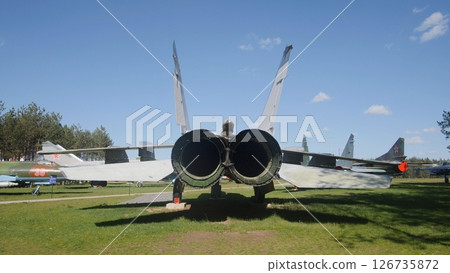 Military Aircraft on Display at an Outdoor Aviation Exhibition Surrounded by Green Grass and Blue Skies in a Park Setting 126735872