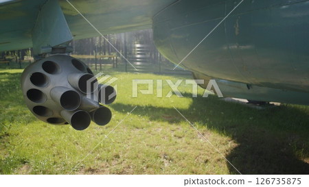 Military Aircraft Weaponry on Display at an Airshow in a Public Park, Showcasing the Intricate Design of the Rocket Pod Under Bright Daylight 126735875