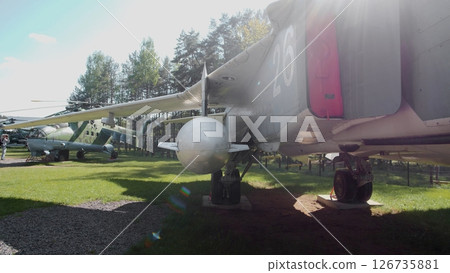 Soviet Military Aircraft Displayed in a Green Field Surrounded by Trees During a Sunny Day in a Historical Aviation Park Soviet Military Aircraft Displayed in a Green Field Surrounded by Trees During a Sunny Day in a Historical Aviation Park 126735881