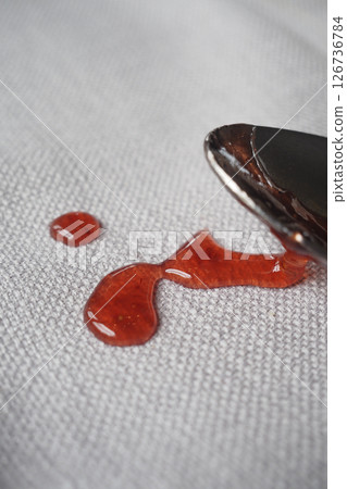 Dripping cherry sauce spilled on a table cloth  126736784