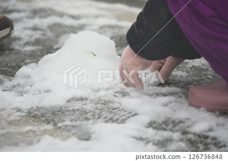 Building a snowball during a winter day outdoors 126736848