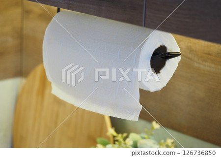 Kitchen paper towel hanging by a wooden shelf 126736850