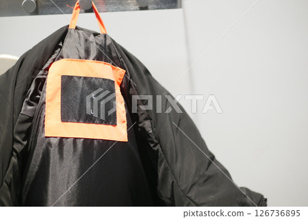 Warm black jacket hanging in a retail store Warm black jacket hanging in a retail store 126736895