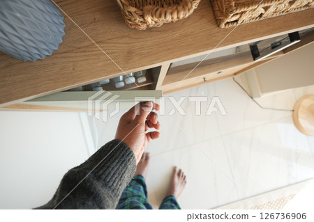 Hand reaching for drawer in modern kitchen space Hand reaching for drawer in modern kitchen space 126736906