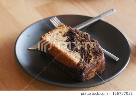 Delicious marble cake served on a black plate Delicious marble cake served on a black plate 126737031