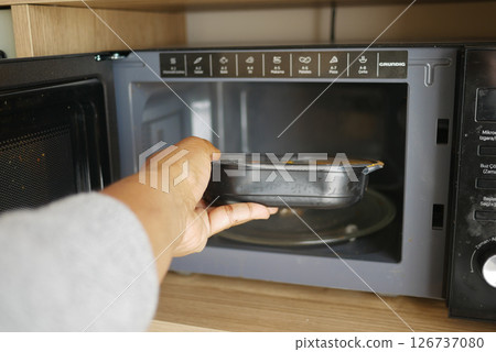 Heating a meal in the microwave at home kitchen 126737080