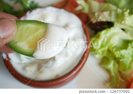 Delicious cucumber slice dipped in creamy yogurt sauce Delicious cucumber slice dipped in creamy yogurt sauce 126737092