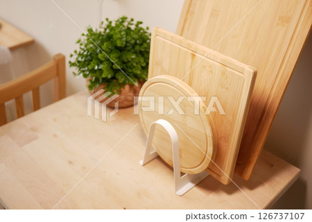 Kitchen display of wooden cutting boards and greenery 126737107