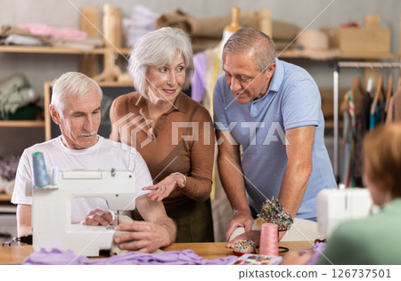 Elderly male teacher shows master class on sewing 126737501