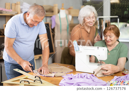 Elderly participants in sewing coterie learn sewing, communicate and talking, sewing, cut fabric by scissors 126737576