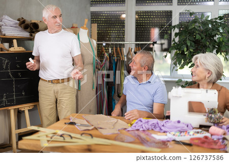 Instructor explaining garment construction at blackboard during sewing class 126737586