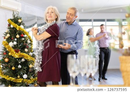 Happy mature woman enjoying impassioned merengue with male partner in dance room during celebration Christmas and New Year. Social dancing concept 126737595