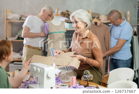 Elderly man and woman working with mannequin and making pattern in class Elderly man and woman working with mannequin and making pattern in class 126737867