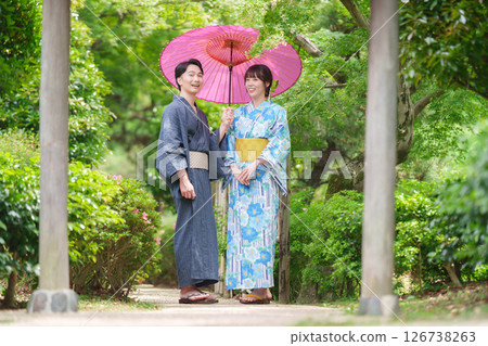 A couple in yukata walking through a Japanese garden 126738263