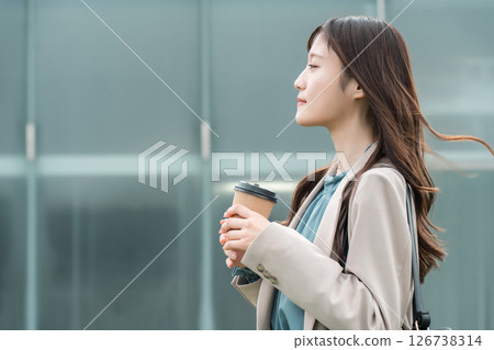 身著辦公室休閒西裝、手拿咖啡的年輕亞洲女商人 126738314