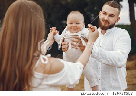 Parents with daughter. Family in a field. Newborn girl. Woman in a white dress. 126738598
