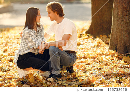 Couple in a park. Guy in a white t-shirt. Golden autumn. 126738656