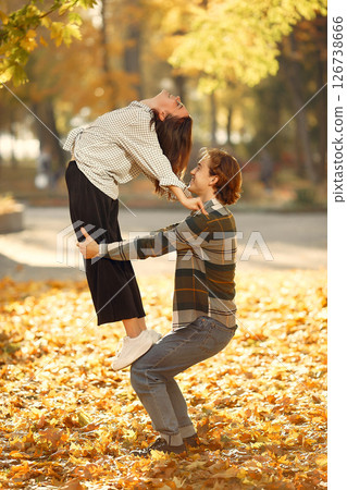 Couple in a park. Guy in a white t-shirt. Golden autumn. 126738666
