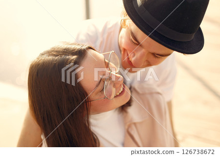 Couple by the water. Guy in a white t-shirt. Pair on a sunset background. 126738672