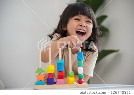 toddler girl playing educational wooden toy 126740551