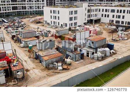 The ongoing development at the construction site features large containers and active work 126740770