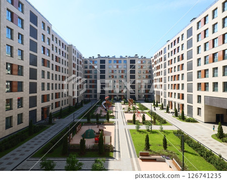 A Modern Residential Complex Featuring Lush Greenery Surrounded by Expansive Open Spaces 126741235