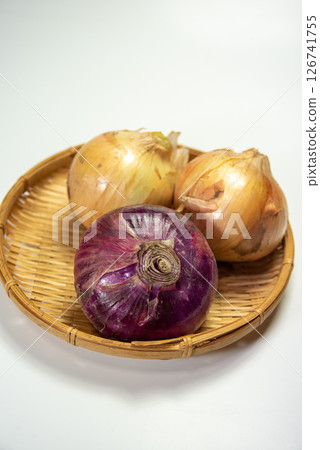 Yellow and purple onions on a colander on a white background Yellow and purple onions on a colander on a white background 126741755