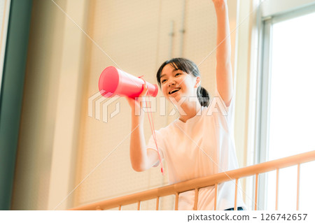 一名身穿運動服的女學生在體育館裡用擴音器歡呼（加油，加油，加油，加油） 126742657